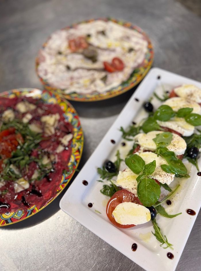 Rindercarpaccio und Caprese mit Büffelmozzarella auf Keramiktellern