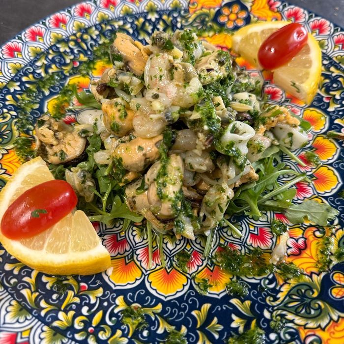Meeresfrüchtesalat auf Rucola mit Zitrone und Tomate
