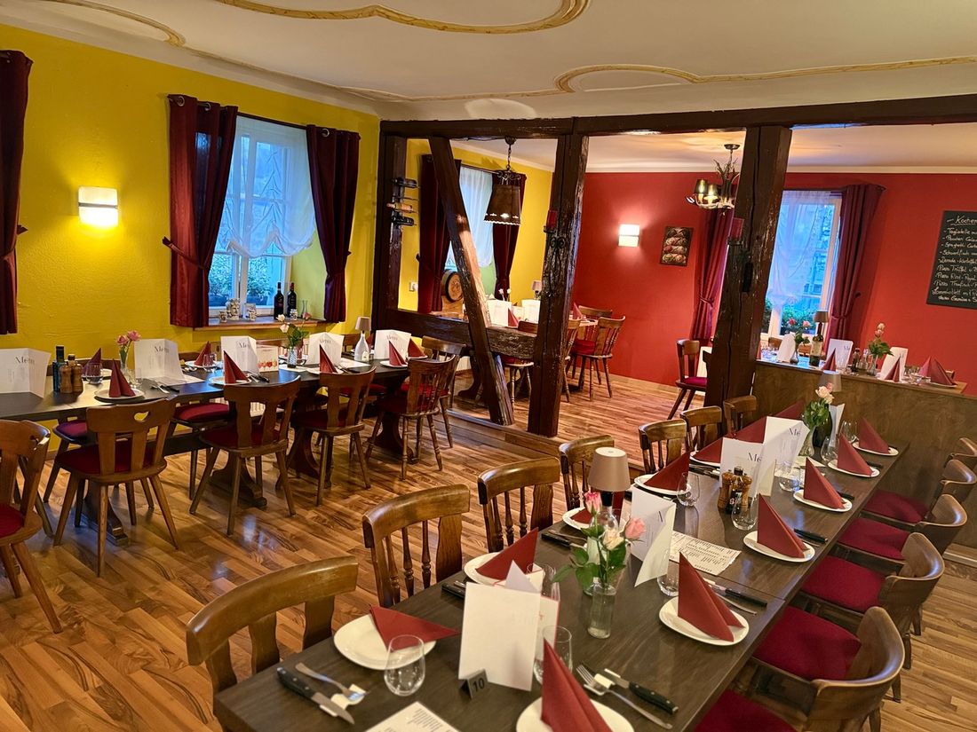 Festlich gedeckter Gastraum von La Piazzetta mit langen Tafeln
